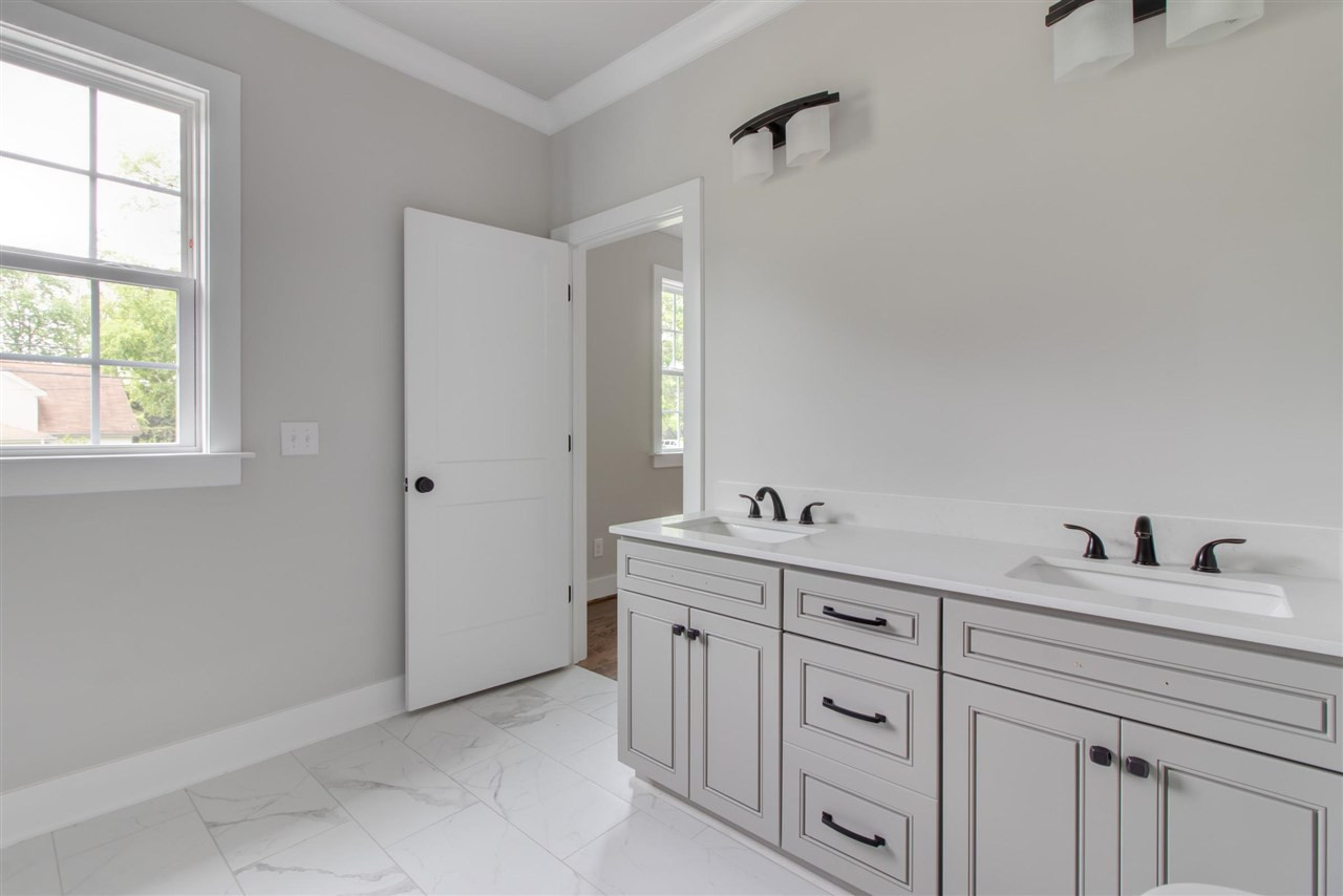 2929 Chapel Hill Road Durham, NC 27707 - Photo 20 of 25 a bathroom with a double vanity sink and a window