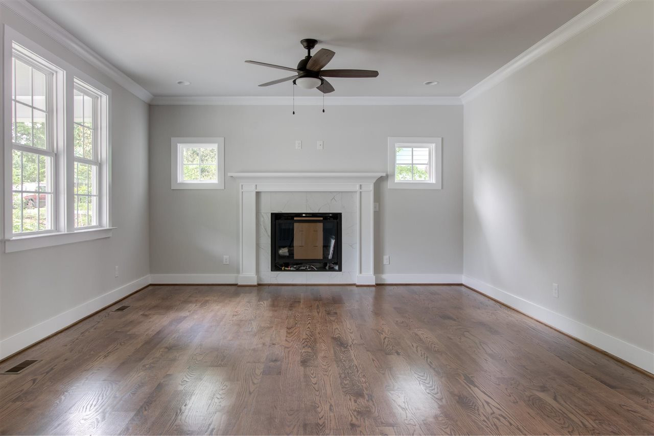 2929 Chapel Hill Road Durham, NC 27707 - Photo 5 of 25 a view of an empty room with wooden floor fireplace and a window