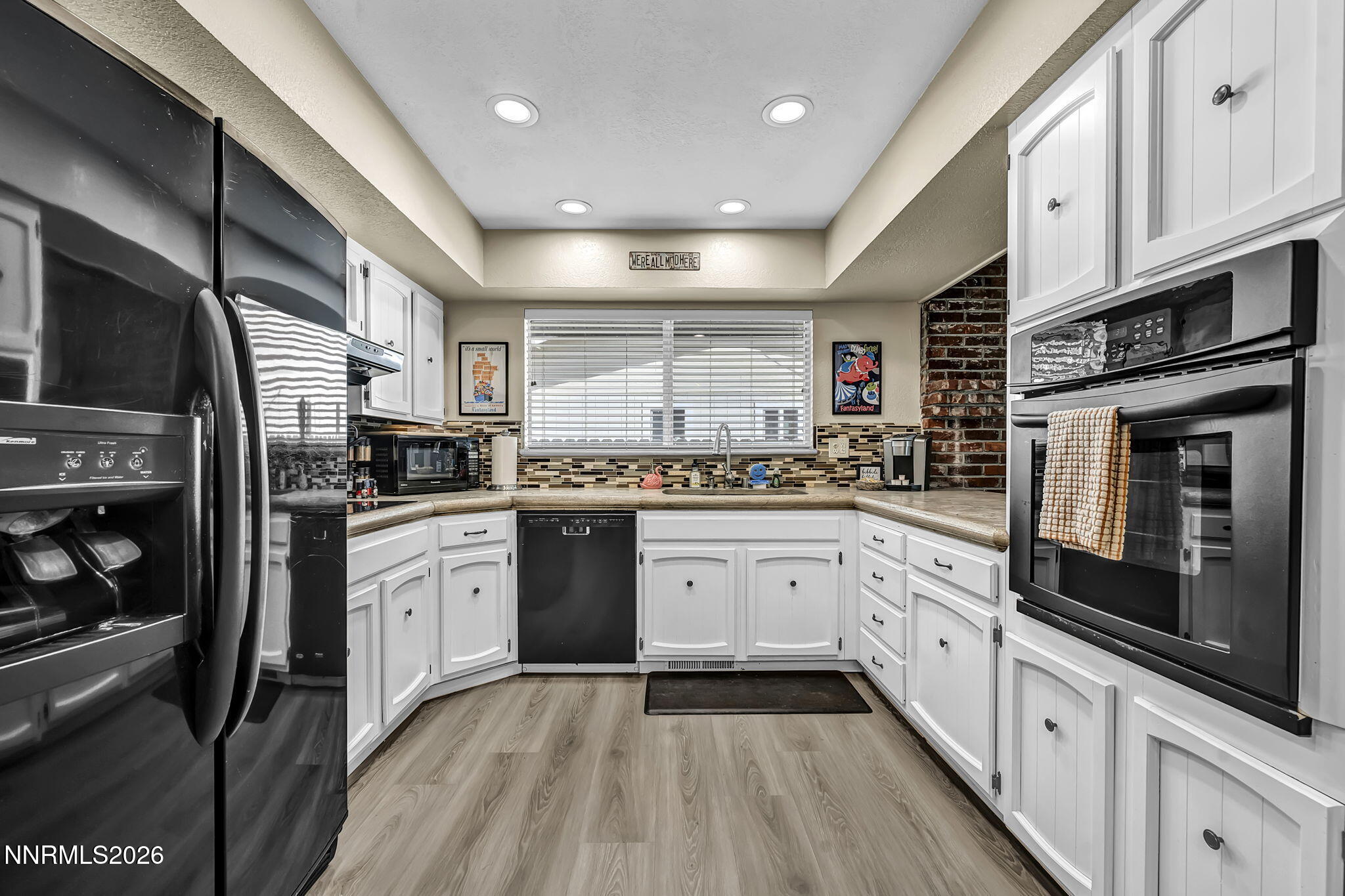 1490 Foster Drive Reno, NV 89509 - Photo 14 of 53 a kitchen with stainless steel appliances kitchen island granite countertop a refrigerator oven a sink dishwasher and white cabinets with wooden floor
