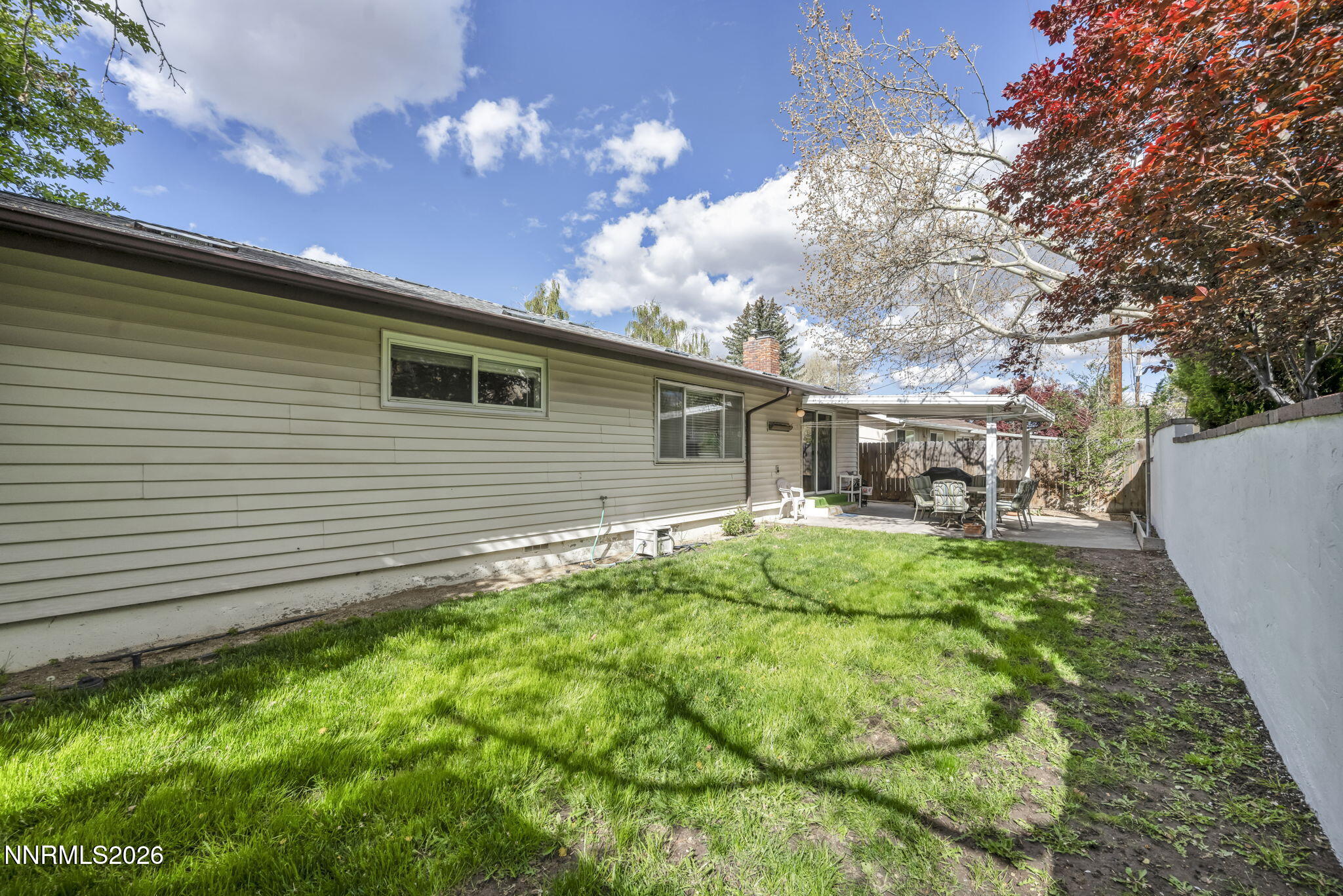 1490 Foster Drive Reno, NV 89509 - Photo 48 of 53 a backyard of a house with table and chairs and a large tree