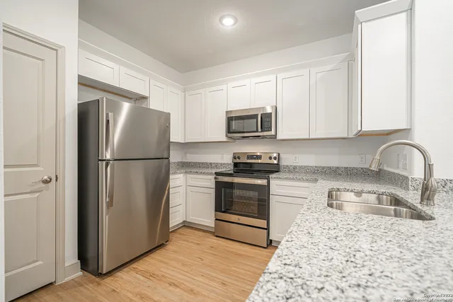 a kitchen with a refrigerator stove and sink