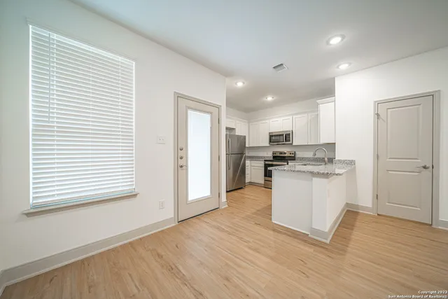 a kitchen with white cabinets and white appliances