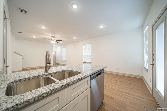 a kitchen with a sink and cabinet with wooden floor