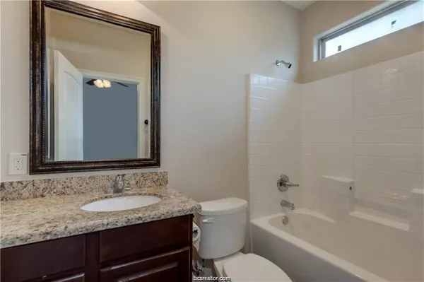 a bathroom with a granite countertop sink toilet and shower
