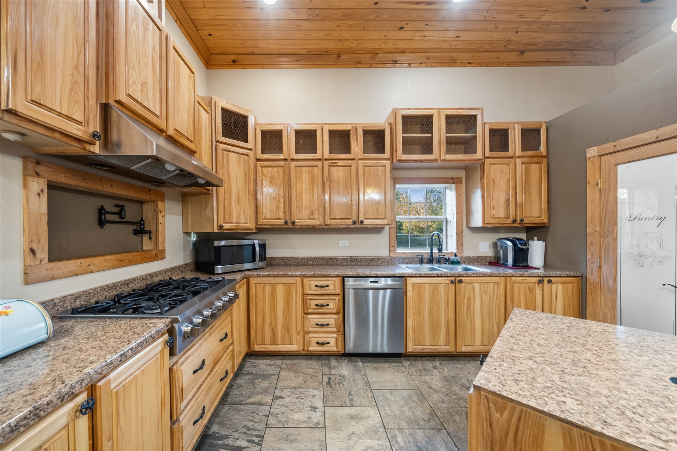 6950 Fm 945 Street North Coldspring, TX 77331 - Photo 9 of 29 a kitchen with stainless steel appliances granite countertop a stove a sink and a microwave