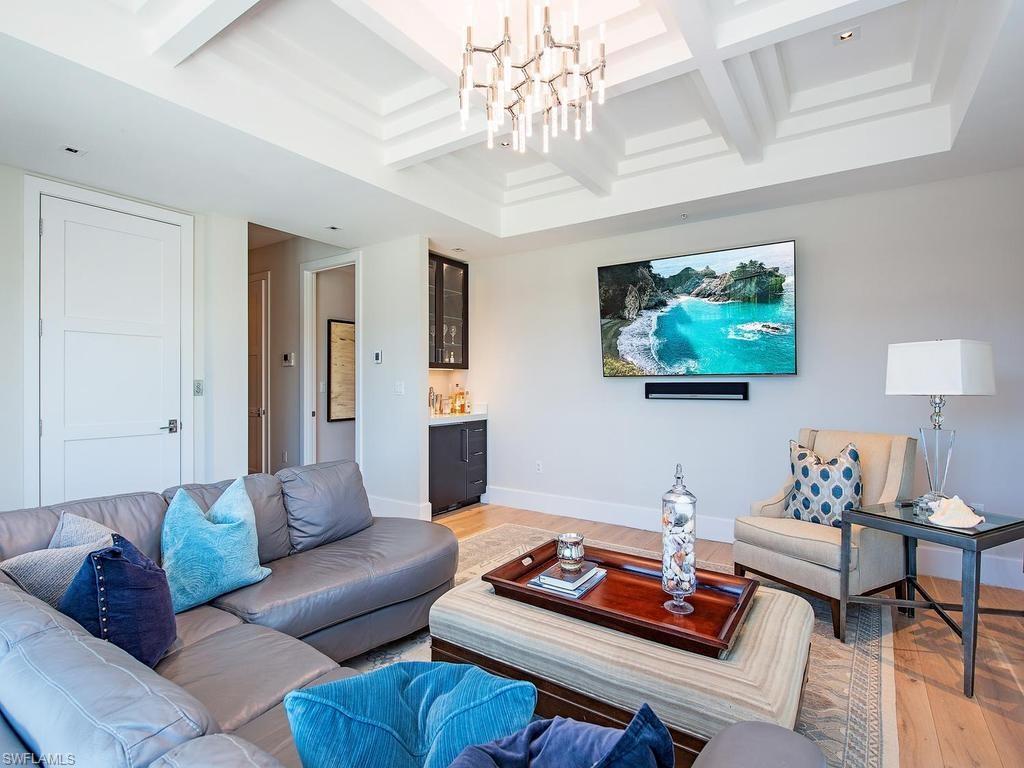 490 5th Street South, Unit 101 Naples, FL 34102 - Photo 8 of 34 a living room with furniture a rug and a chandelier