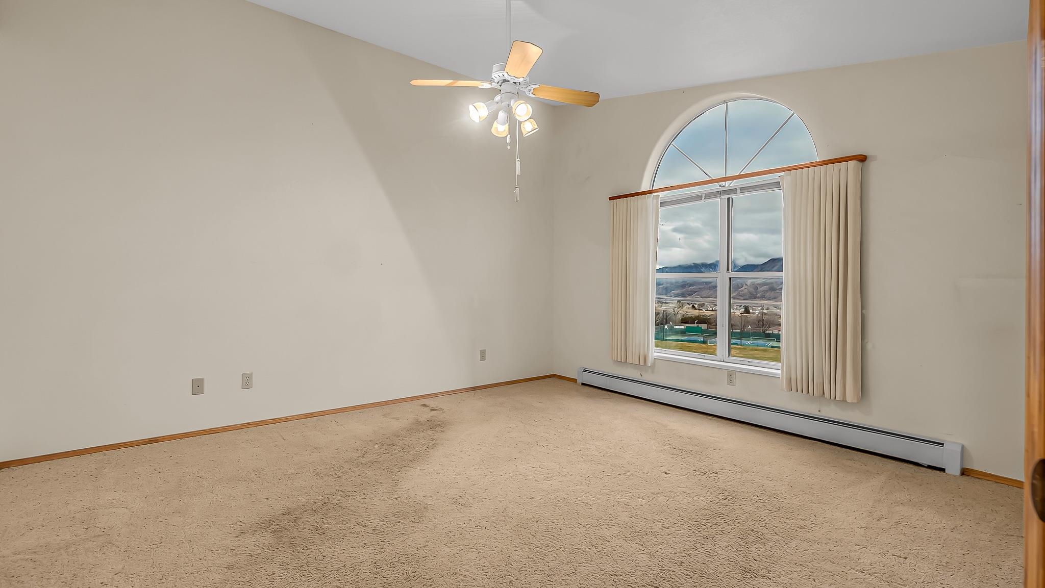 12 West Ridge Court Parachute, CO 81635 - Photo 9 of 37 an empty room with a chandelier fan and windows