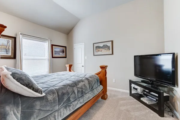 a bedroom with bed and a flat screen tv