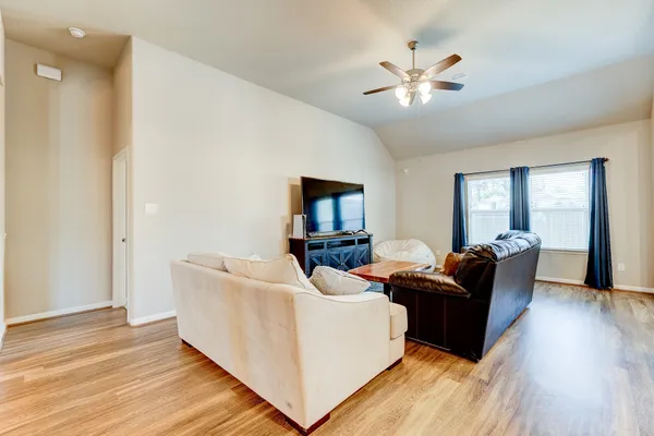 a living room with furniture and a ceiling fan