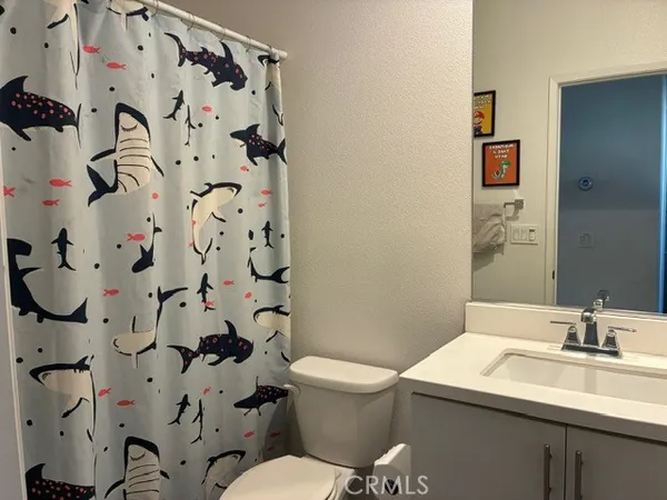 a bathroom with a sink and mirror with toilet