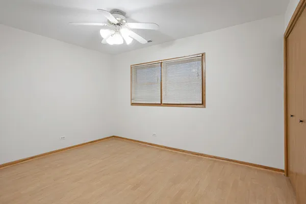 an empty room with a window and a fan