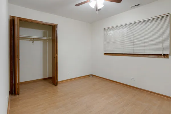 an empty room with a chandelier fan