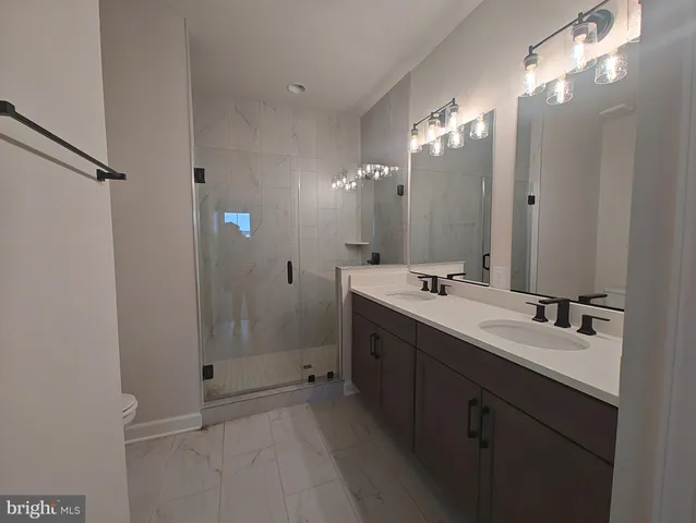 a bathroom with a double vanity sink mirror and shower