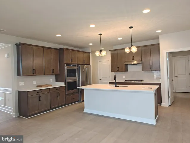 a large kitchen with a stove and a refrigerator
