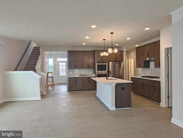 a large kitchen with a large counter top stainless steel appliances and cabinets