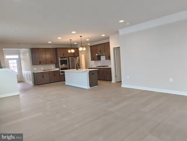 a large kitchen with a large counter top stainless steel appliances and cabinets