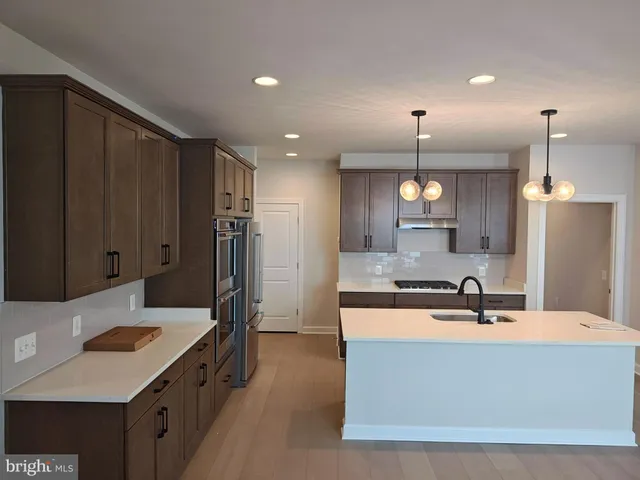 a large kitchen with kitchen island a sink stainless steel appliances and cabinets