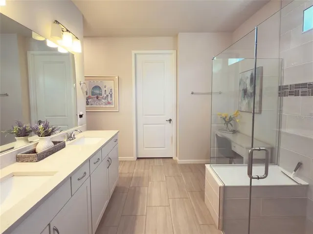 a spacious bathroom with a double vanity sink mirror and shower