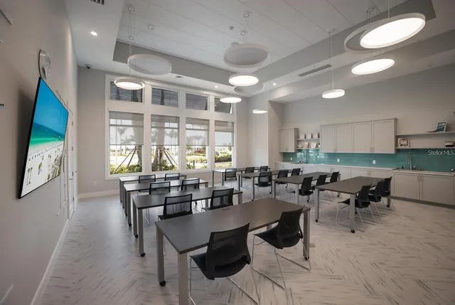 a kitchen with stainless steel appliances a refrigerator a stove a sink and a dining table