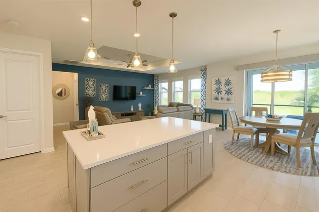 a large kitchen with kitchen island a stove a sink a dining table and chairs with wooden floor