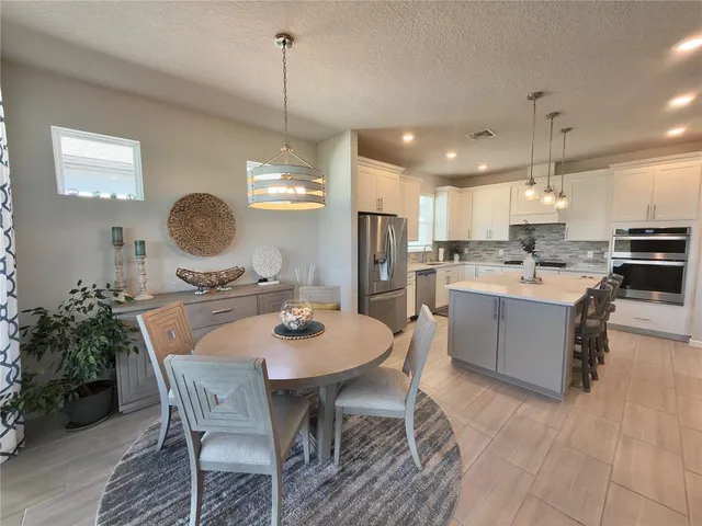 a large kitchen with a table and chairs