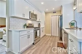 a kitchen with white cabinets and appliances