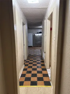 a view of a hallway with a black and white checkered floor