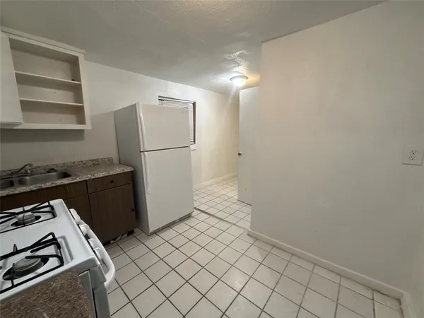 a kitchen with a refrigerator and a stove top oven
