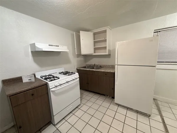 a kitchen with a stove top oven and cabinets