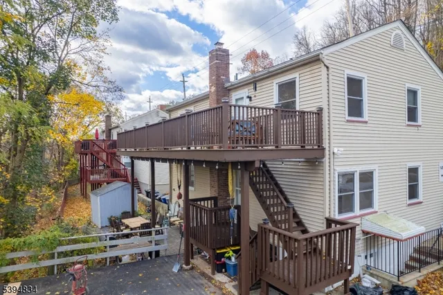 a view of a house with wooden deck front of house