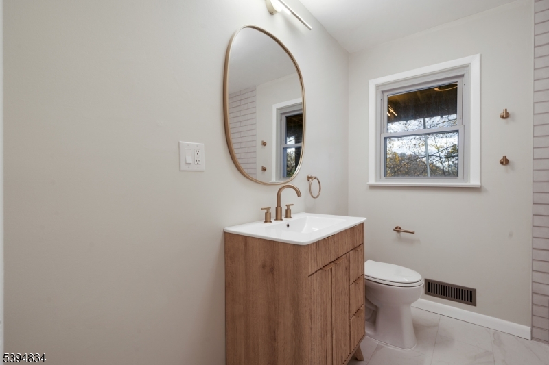 76 Mt Kemble Avenue, Unit 1 Morristown, NJ 07960 - Photo 8 of 20 a bathroom with a toilet a sink and mirror