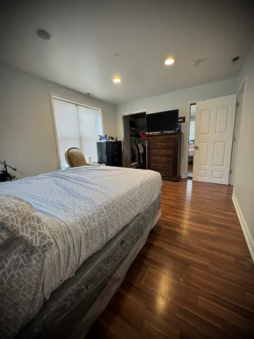 a spacious bedroom with a bed and a flat screen tv