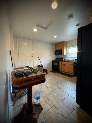a kitchen with a stove a refrigerator and chairs