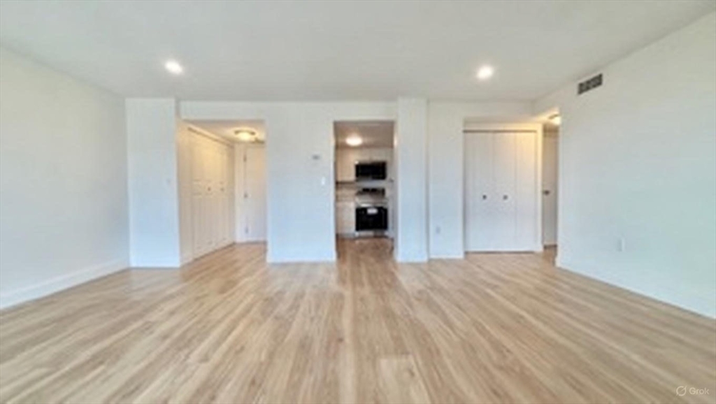 12 Chancery Court, Unit 404 Lynn, MA 01902 - Photo 6 of 10 a view of a big room with wooden floor and windows
