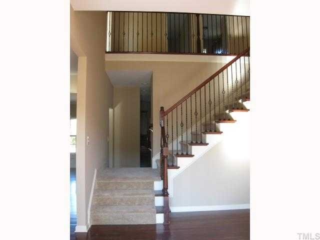 2105 Lower Lake Road Wake Forest, NC 27587 - Photo 3 of 12 Looking from front door into large foyer area. Study w/French doors to your right, living room to left. Stairs cross over into kitchen! Note the gorgeous iron rail & open tread on these stairs & hallway above! Foyer