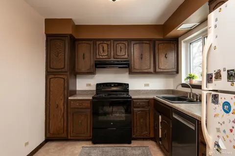 a kitchen with granite countertop a stove top oven microwave and cabinets