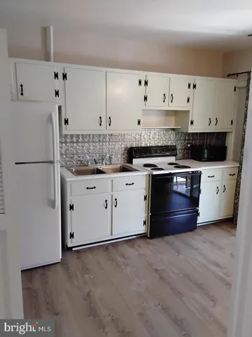 a kitchen with cabinets a sink and white stainless steel appliances