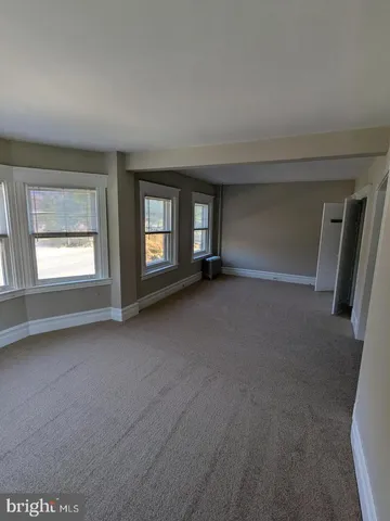 an empty room with a fireplace and windows