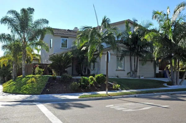 a front view of a house with a yard and potted plants