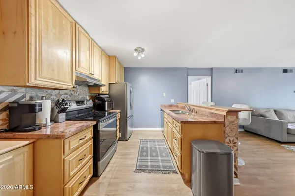 a kitchen with stainless steel appliances granite countertop a stove a sink and a refrigerator
