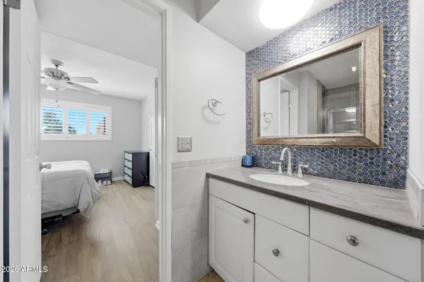 a en suite bathroom with a granite countertop tub and a mirror