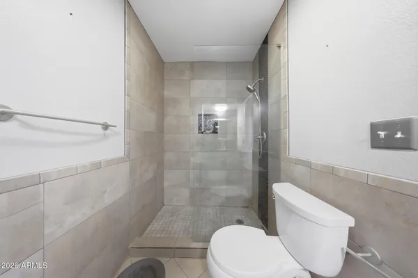 a white toilet sitting next to a shower