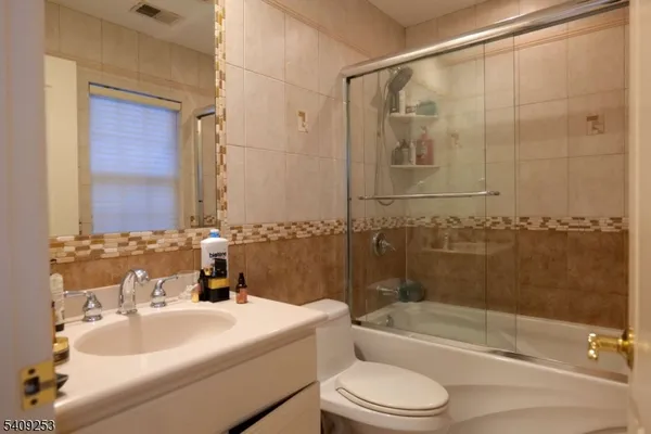 a bathroom with a bathtub shower sink vanity and toilet