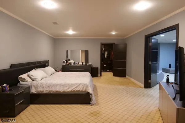 a large bedroom with a bed and a large mirror
