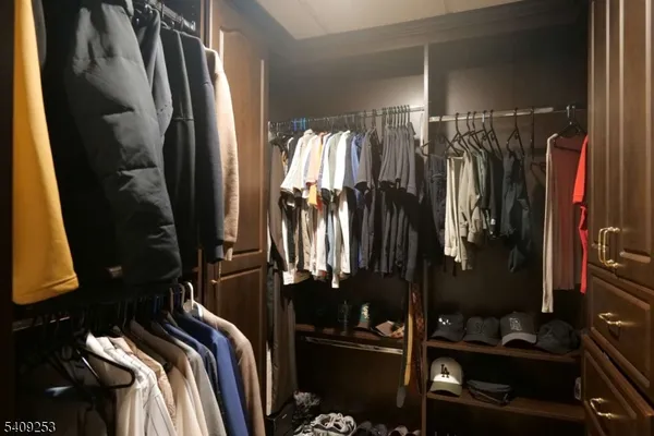 a view of walk in closet with clothes and shoes