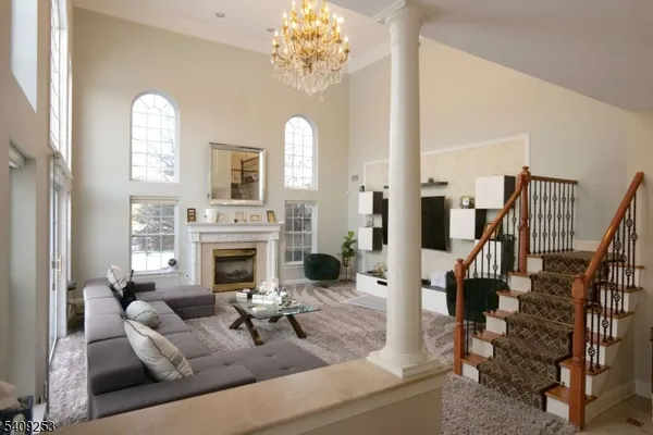 a living room with furniture a fireplace and a chandelier