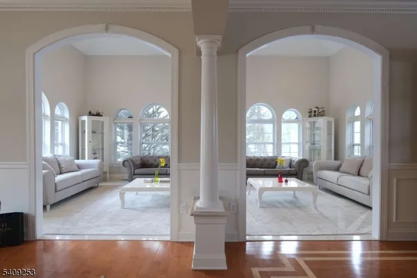 a living room with couches and dining table with wooden floor