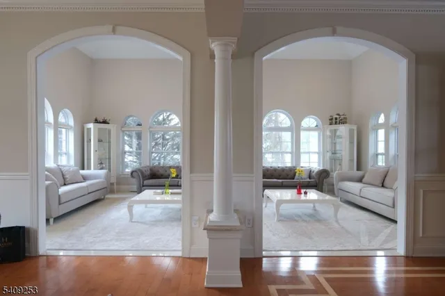 a living room with couches and dining table with wooden floor