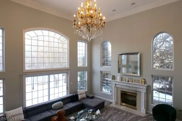 a living room with furniture a chandelier and a fireplace