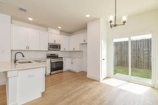 a kitchen with kitchen island a sink stainless steel appliances and cabinets